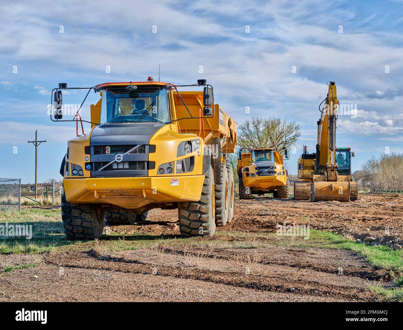 Fort Collins, CO, USA - 28. April 2021: Leistungsstarke Sattelkipper Volvo A45G und CAT-Bagger auf einer Baustelle. Stockfoto