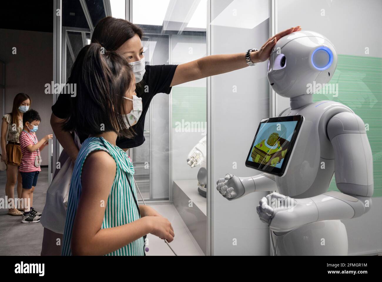 Hongkong, China. Mai 2021. Eine Frau berührt den Kopf eines Roboters  während der Ausstellung „ROBOTER“ im Hong Kong Science Museum in Hongkong  am 8. Mai 2021. Die Ausstellung untersucht die 500-jährige Geschichte