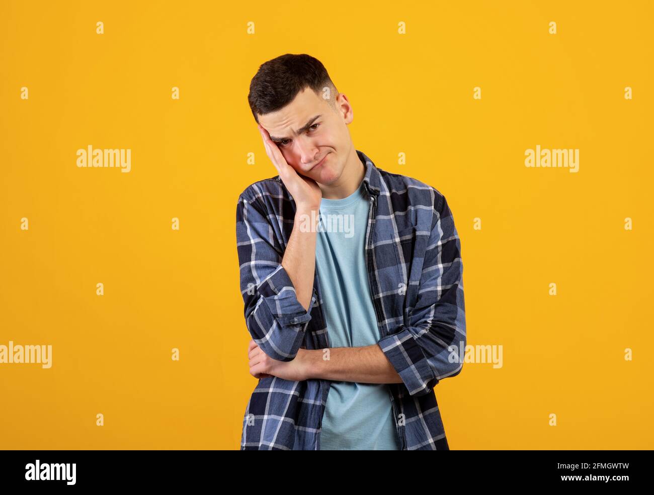 Porträt von verärgerten kaukasischen Kerl in Freizeitkleidung Blick auf die Kamera in Frustration, orangen Studio-Hintergrund Stockfoto