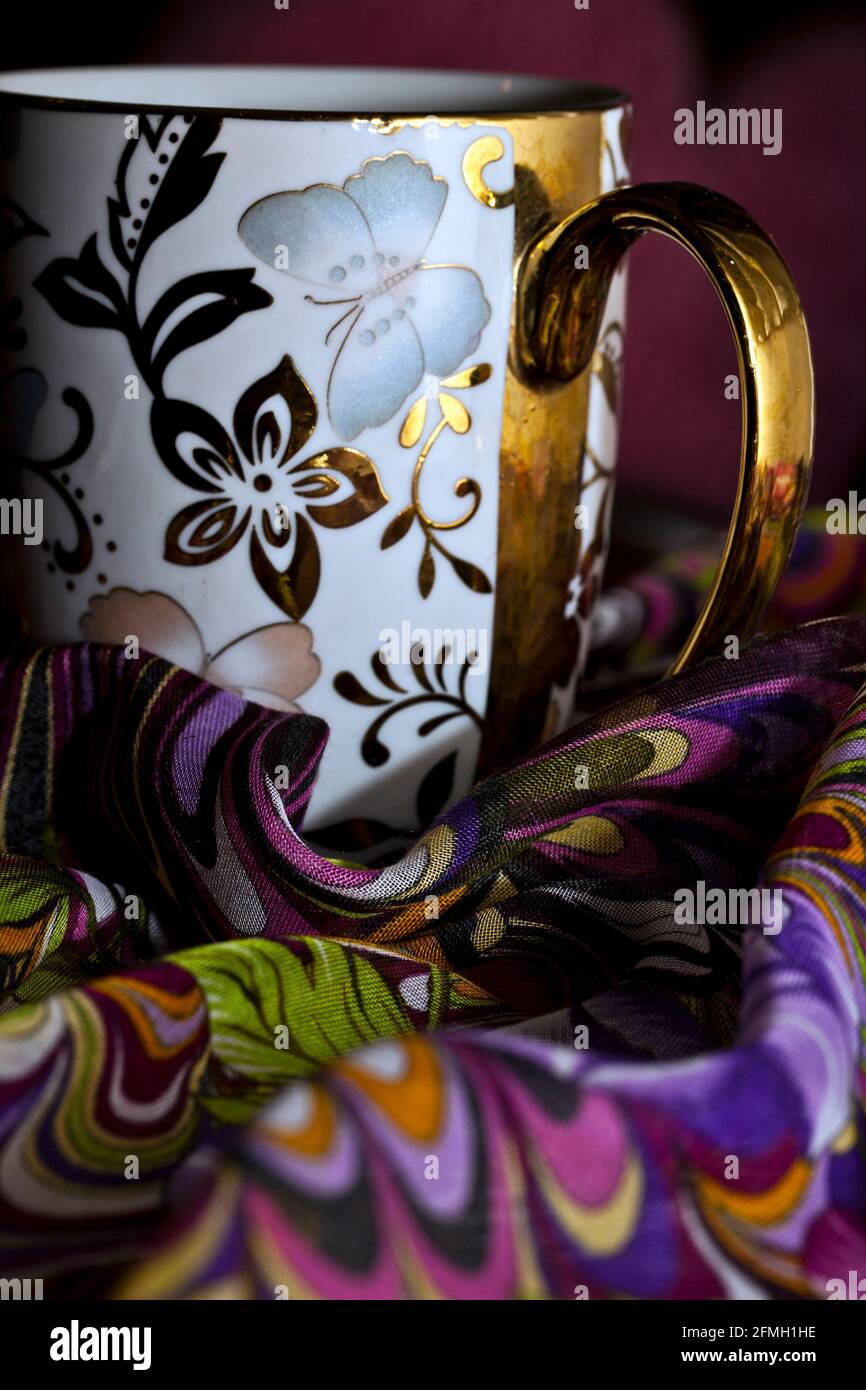 Dekorative Kaffeetasse auf buntem Stofffoto Stockfoto