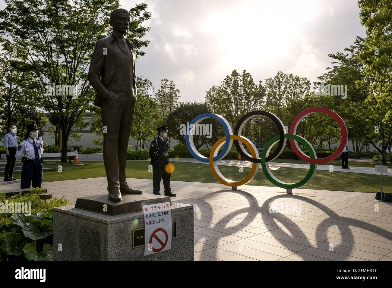 Tokio, Japan. Mai 2021. Während eines Protestes gegen die Olympischen Spiele in Tokio beschützen Polizeibeamte eine Bronzestatue von Pierre de Coubertin, die vor dem Olympischen Platz von Japan Sport in Shinjuku aufgestellt wurde. Bis zur Eröffnung der Olympischen Spiele 2020 in Tokio bleiben weniger als 3 Monate, und in Japan besteht weiterhin die Sorge über die Möglichkeit, während der laufenden COVID-19-Pandemie ein so großes Ereignis zu veranstalten. Kredit: SOPA Images Limited/Alamy Live Nachrichten Stockfoto