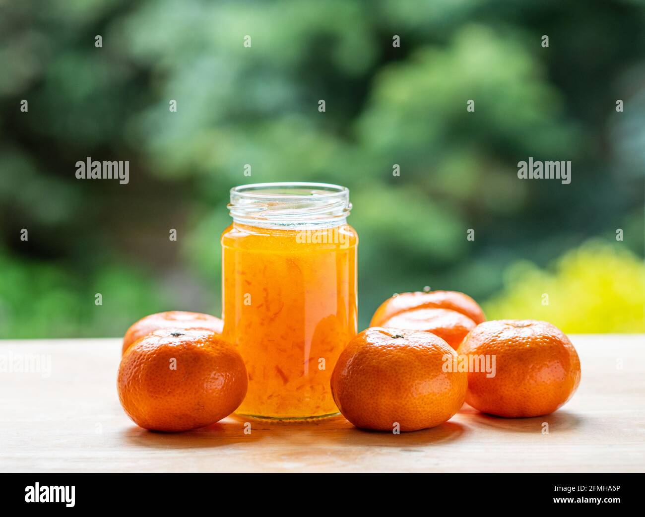Glas Orangenmarmelade kein Etikett mit Früchten mit einem Grüner Hintergrund ohne Fokus Stockfoto