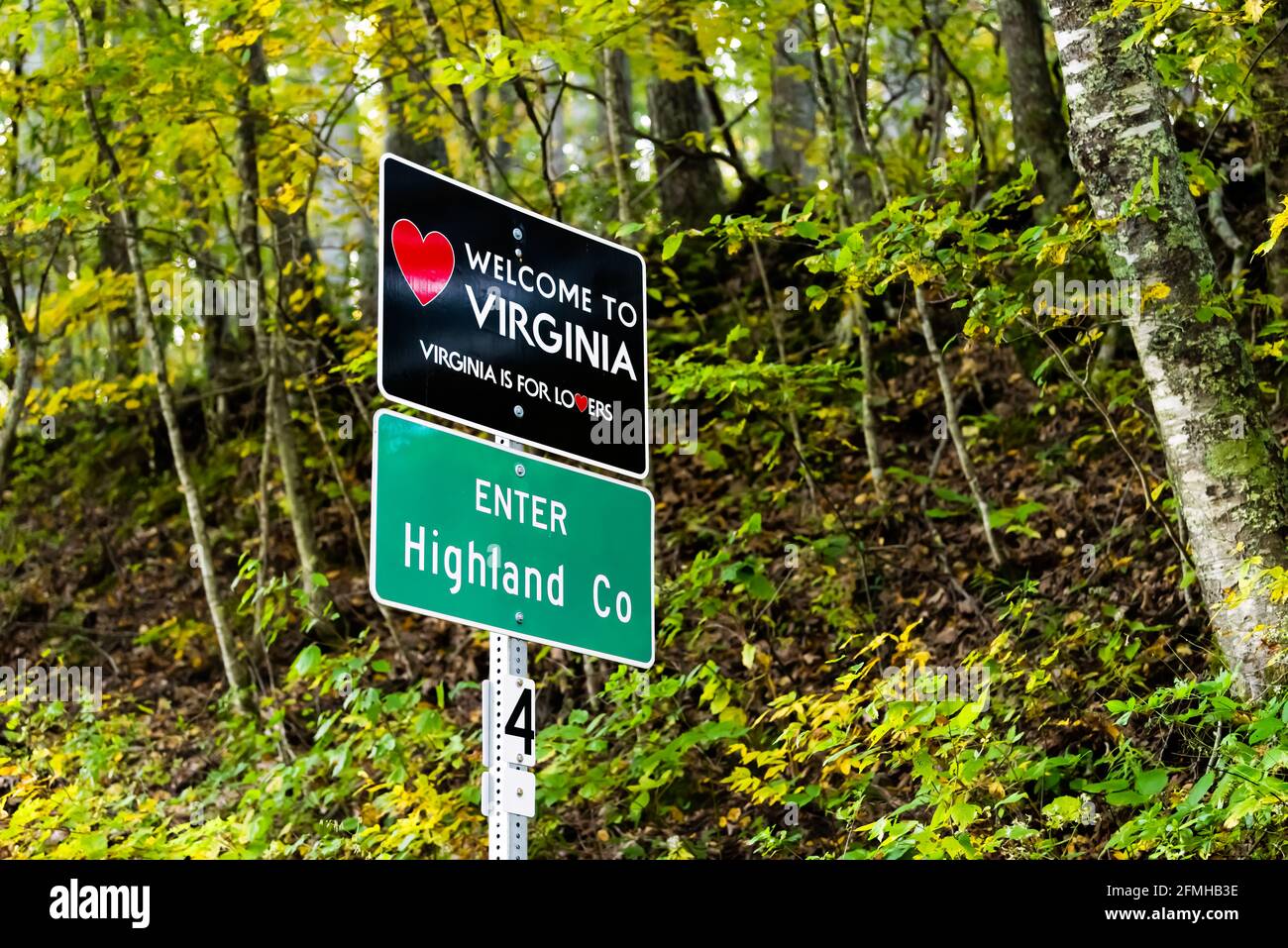 Rotes Herz Zeichen auf der Autobahn in Virginia mit willkommen zu Staat Zeichen und ist für Liebhaber Text-Logo in Highland County, VA durch Bergwald mit Nebel Stockfoto
