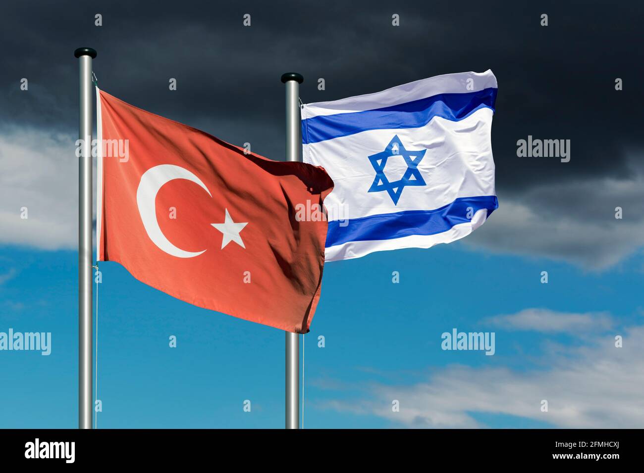 Staatsflaggen Israels und der Türkei vor einem dunklen Himmel, symbolisches Bild für die Beziehungen zwischen Israel und der Türkei Stockfoto
