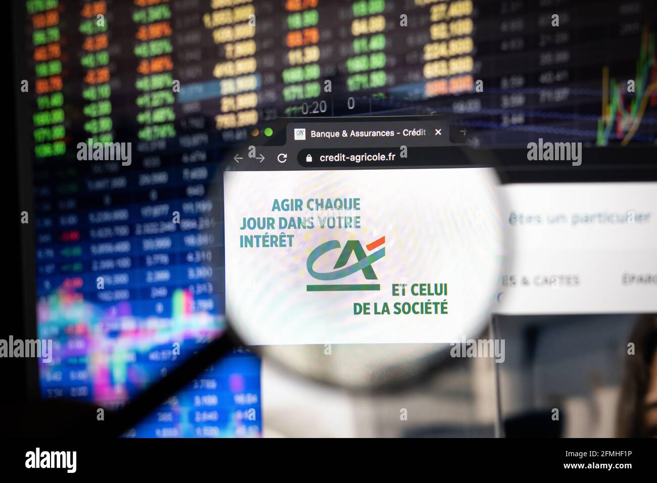 Unternehmenslogo von Crédit Agricole auf einer Website mit verschwommenen Börsenentwicklungen im Hintergrund, auf einem Computerbildschirm gesehen Stockfoto