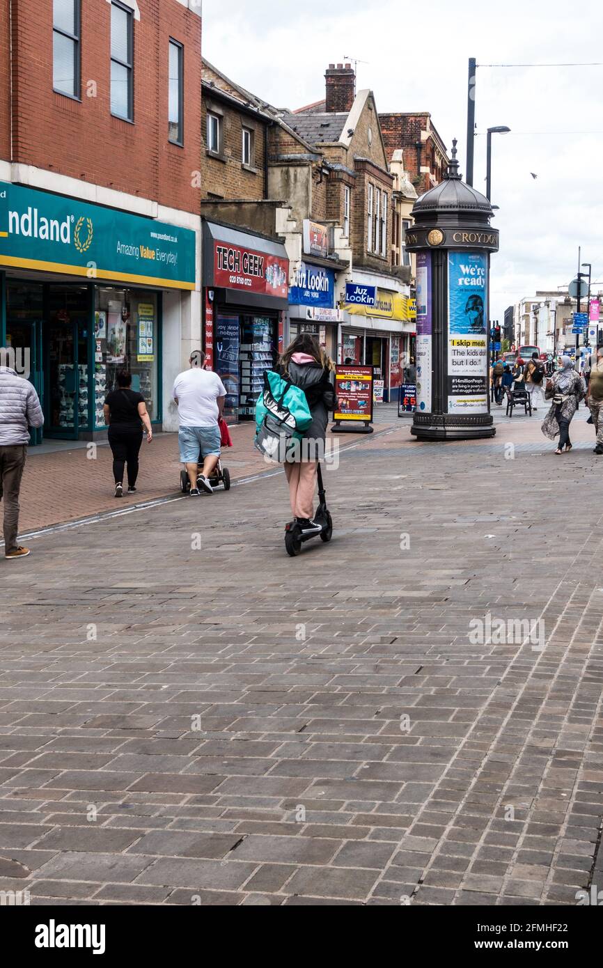 Food Delivery Company Deliveroo Partner Reiten Elektroroller oder E-Scooter  auf Fußgängerzone Stockfotografie - Alamy