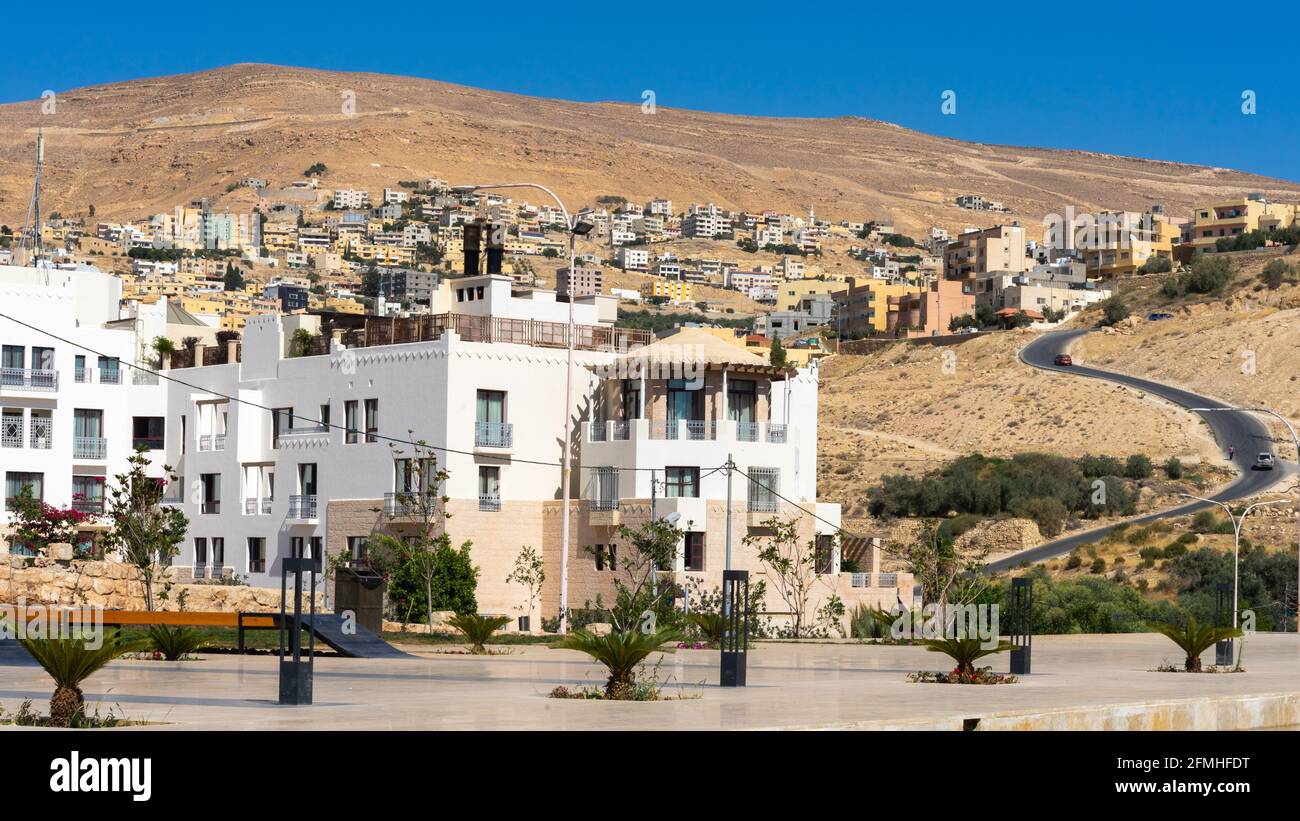 Die Bergstadt Wadi Musa, Jordanien, mit flachen Wohn- und Hotelgebäuden und Straßen unter klarem blauen Himmel an einem Sommertag Stockfoto