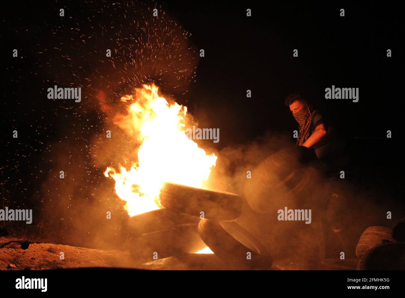 Gaza. Mai 2021. Ein palästinensischer Protestler verbrennt am 9. Mai 2021 während eines anti-israelischen Protestes gegen die Gewalt in Jerusalem an der Grenze zwischen Gaza und Israel östlich von Gaza-Stadt Reifen. Rund 290 Palästinenser wurden am Wochenende bei Zusammenstößen mit der israelischen Polizei auf dem Al-Aqsa-Moschee-Gelände und anderen Teilen von Ostjerusalem verletzt. Kredit: Rizek Abdeljawad/Xinhua/Alamy Live Nachrichten Stockfoto