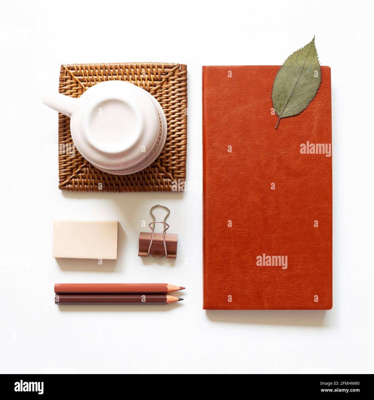 Schreibtisch. Notizbuch, farbiger Pencel, Clip, Radierer, Tasse auf weißem Hintergrund. Draufsicht, Kopierbereich Stockfoto