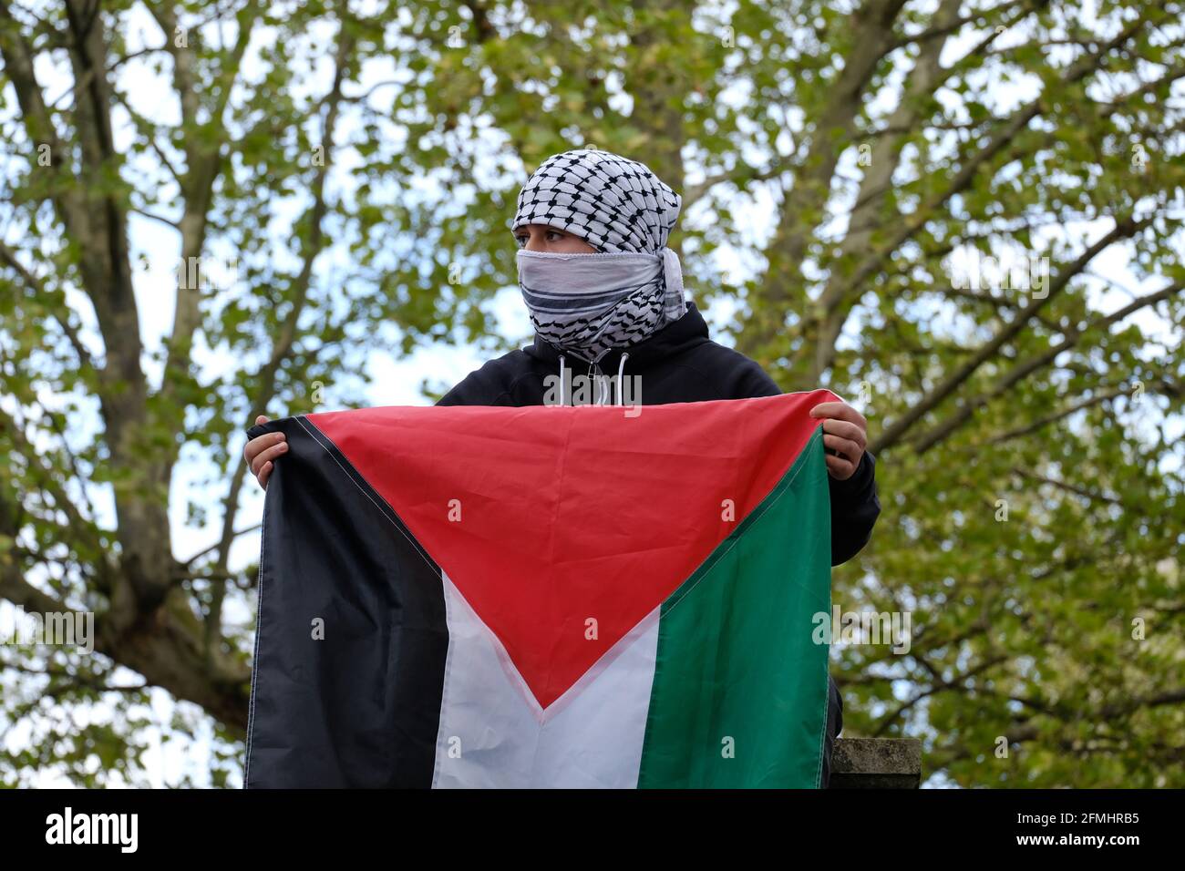 Ein Protestler hält eine palästinensische Fahne hoch während eines Protestes gegen die geplante Räumung von Familien in Scheich Jerrah, Jerusalem für israelische Siedler. Stockfoto