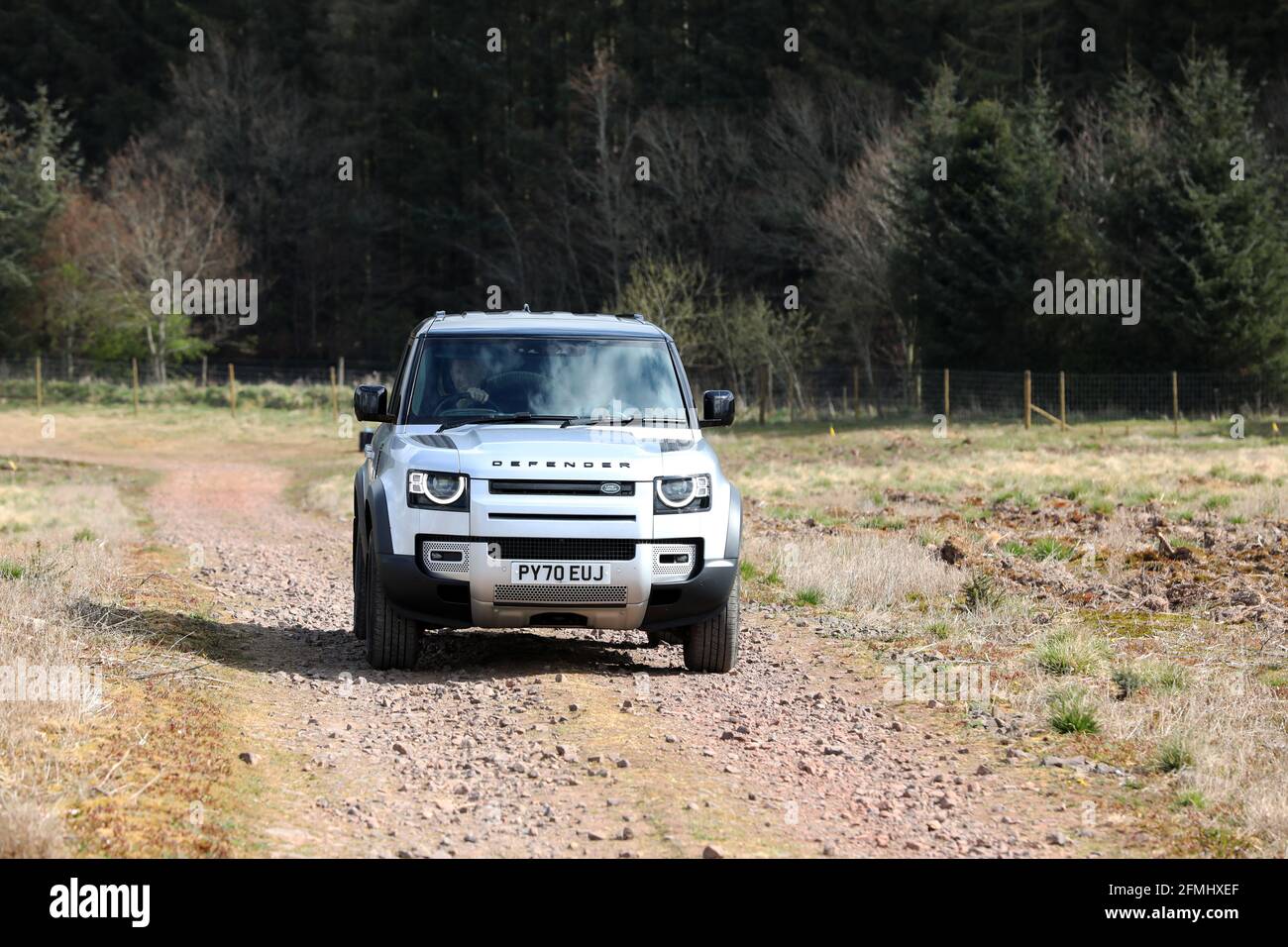 Ein neuer Land Rover Defender im Bild, der in Schottland, Großbritannien, über Land fährt. Stockfoto