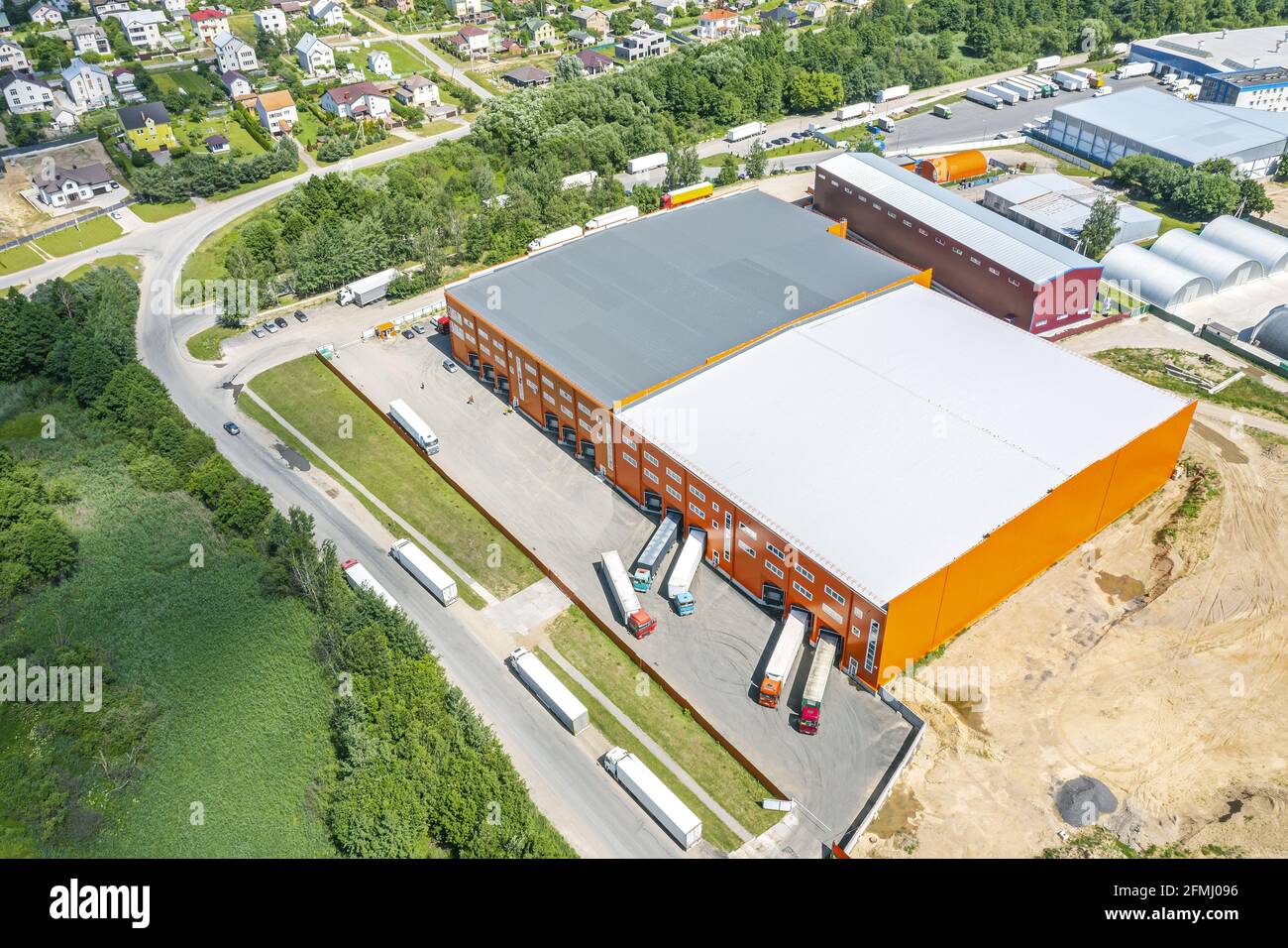 Logistikzentrum im städtischen Industriegebiet von oben. Luftaufnahme von Warenlager und LKWs. Stockfoto