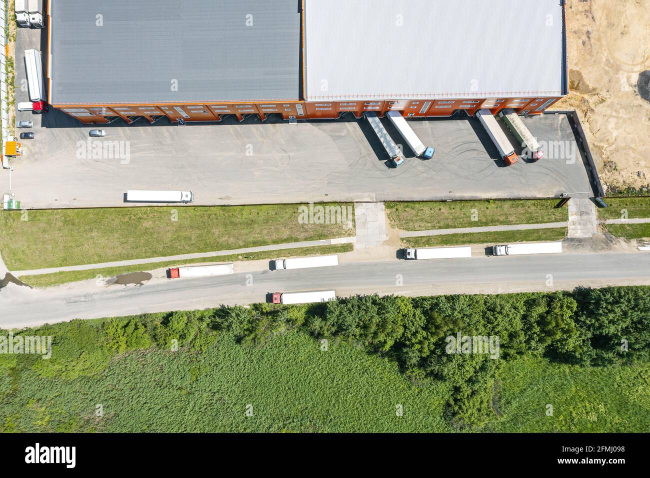 Frachtrailer entladen Waren im Logistikzentrum. Luftaufnahme von oben Stockfoto