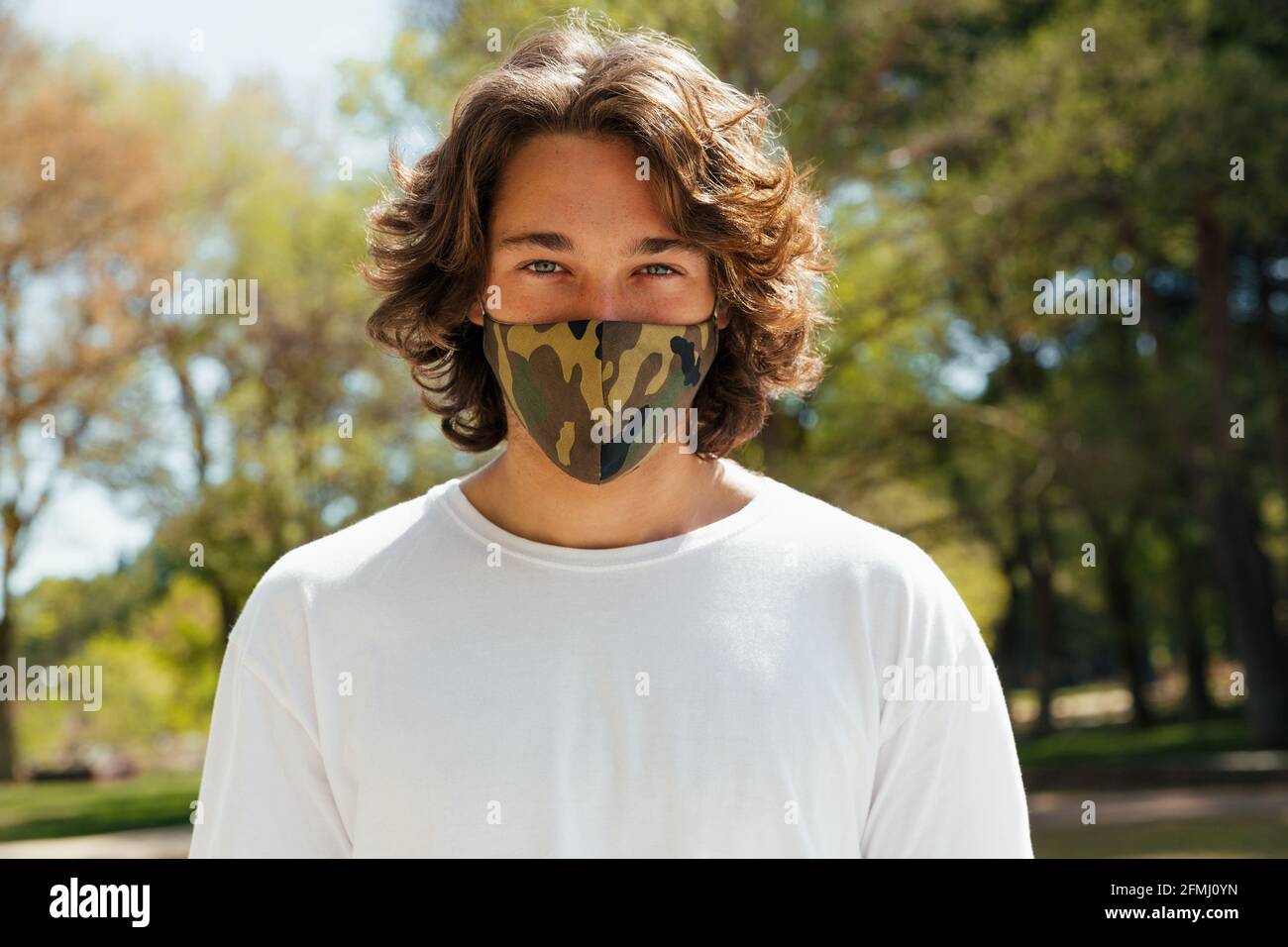 Junger Mann mit Maske schaut auf die Kamera Stockfoto