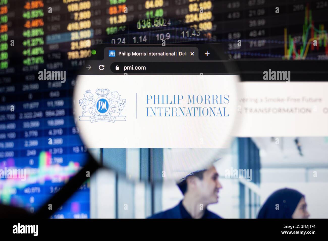 Firmenlogo von Philip Morris International auf einer Website mit verschwommenen Börsenentwicklungen im Hintergrund, die auf einem Computerbildschirm zu sehen sind Stockfoto
