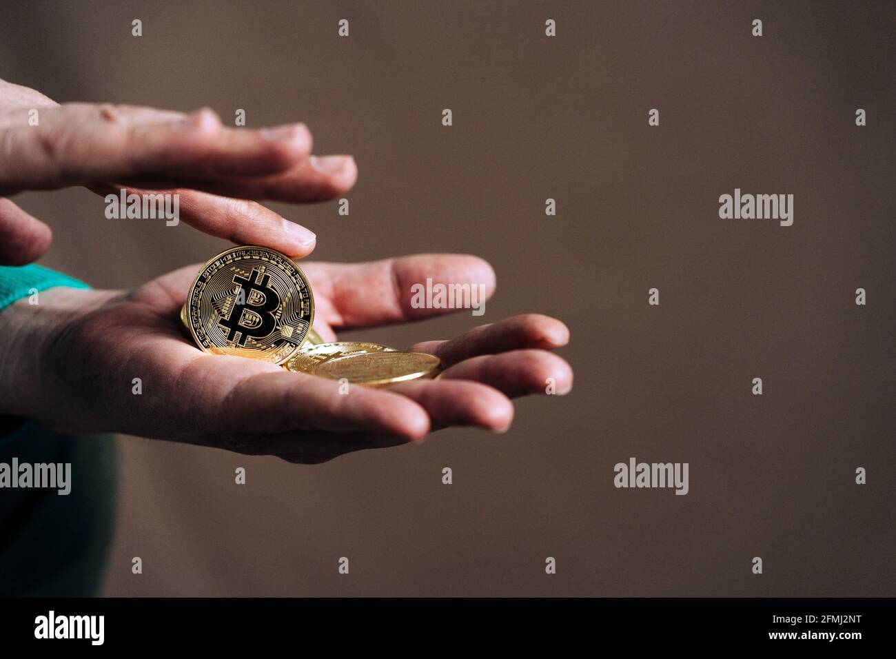 Crop unkenntlich Händler mit Metall Krypto-Münzen mit Buchstaben und Ornament auf goldener Oberfläche Stockfoto