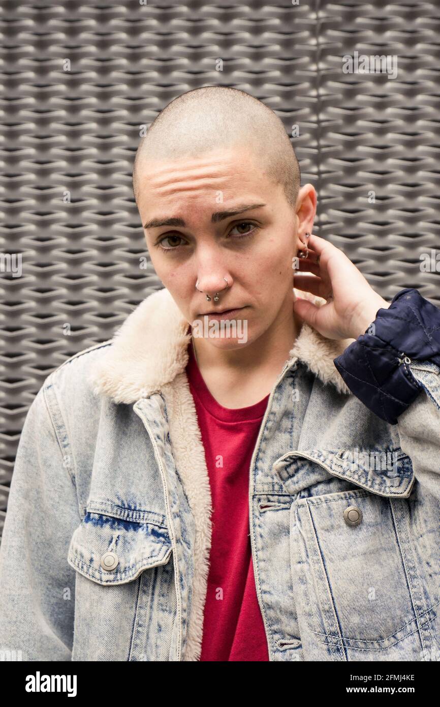 Transgender Person in Denim Jacke mit Fell und Ohrringe suchen Bei  Tageslicht vor der Kamera Stockfotografie - Alamy