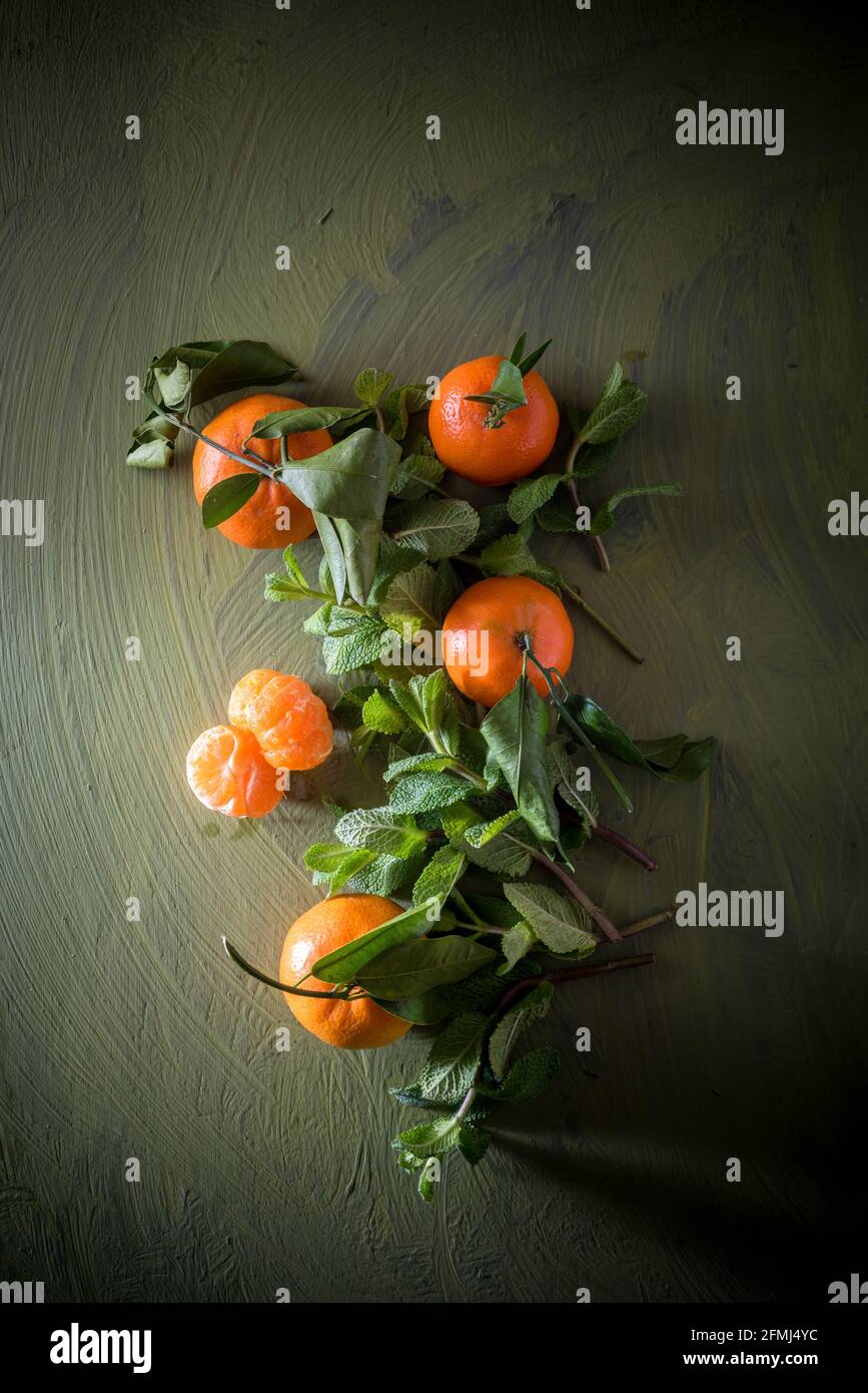 Von oben Mandarine mit Pediküre und Laub an der Oberfläche in der Nähe Pfefferminzbonblatten Stockfoto