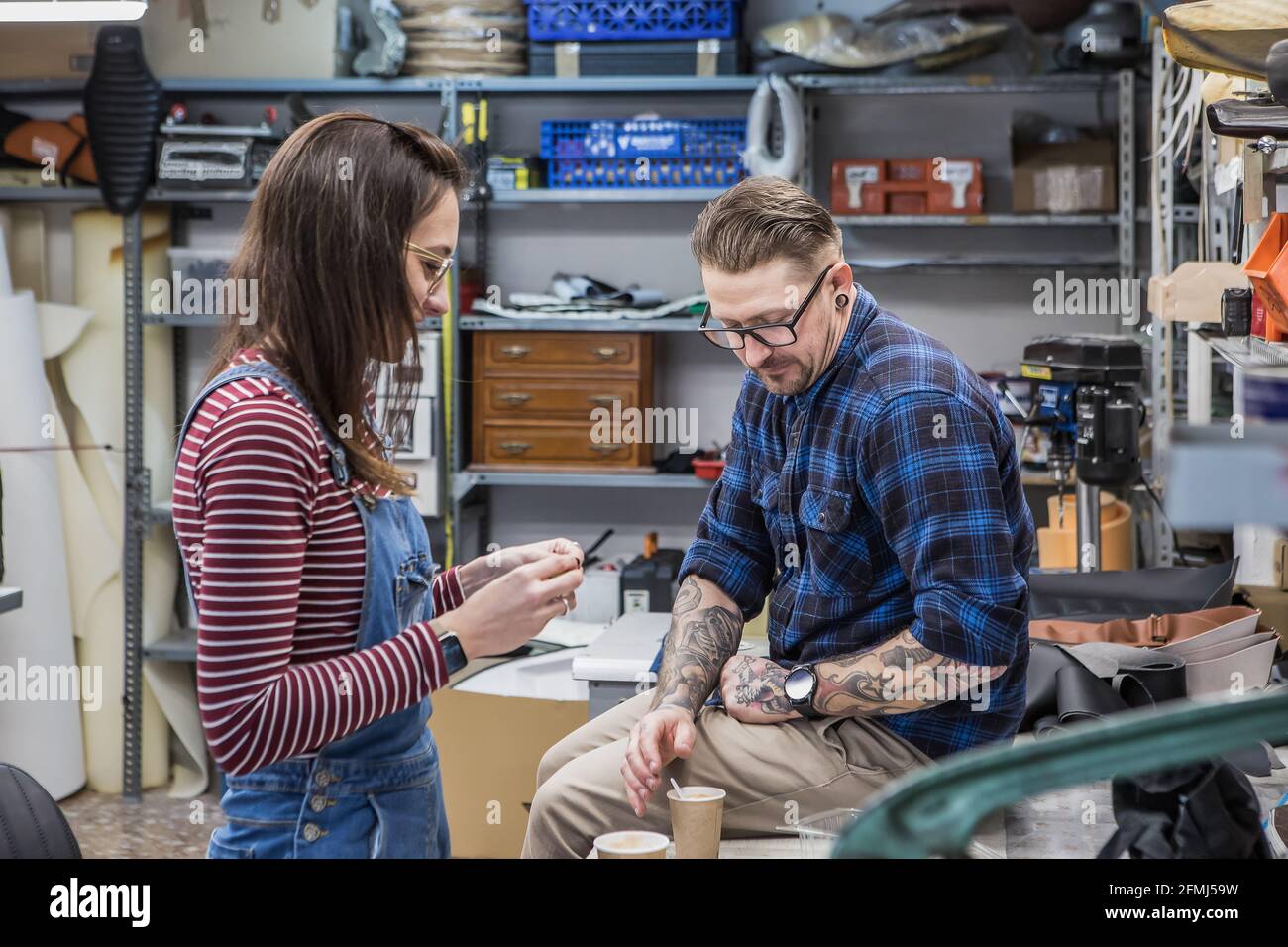 Seitenansicht von ein paar Kunsthandwerkern, die während der Kaffeepause eine Kaffeepause einlegen Arbeiten Sie in einer kreativen Werkstatt Stockfoto
