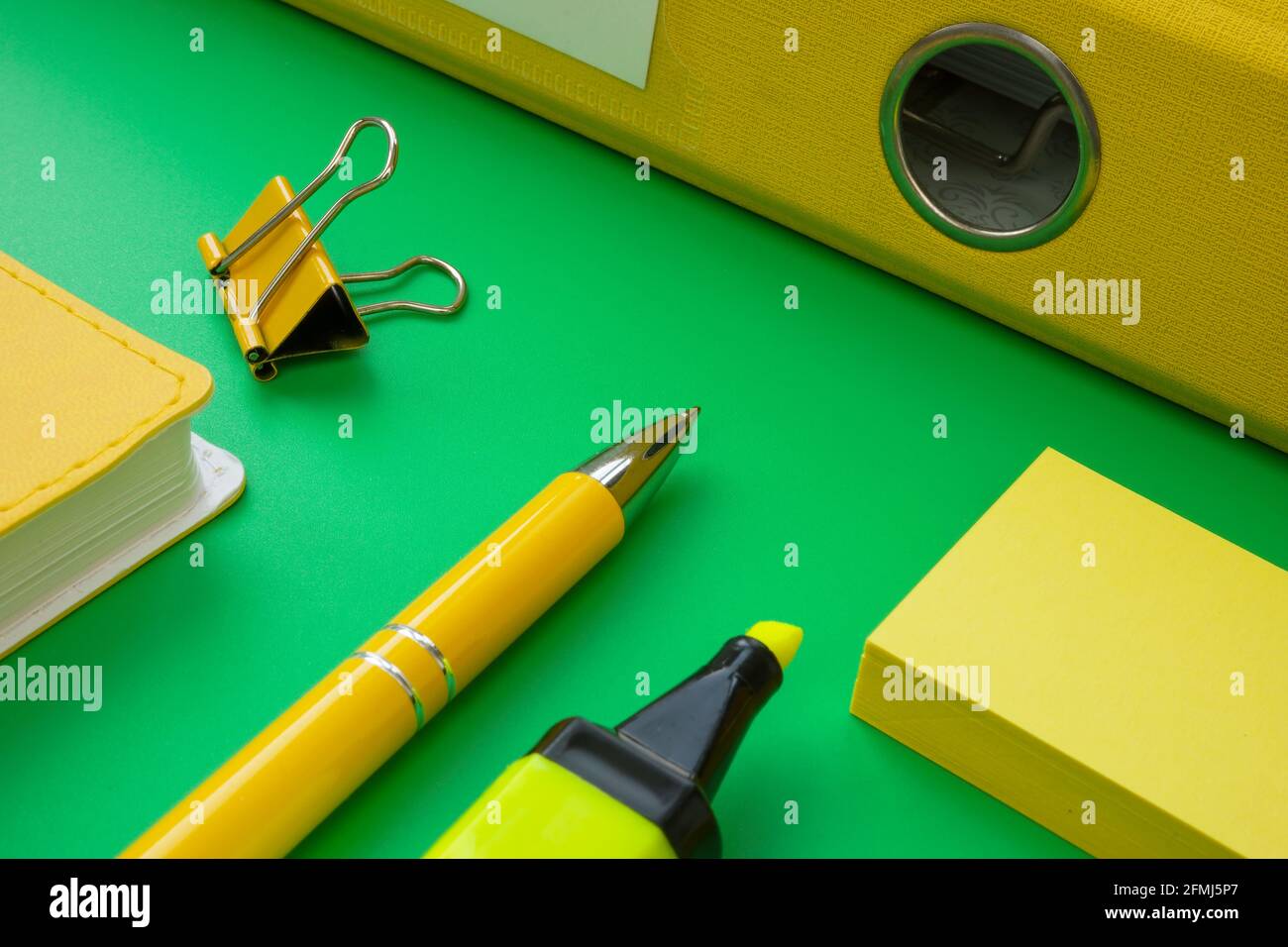 Papierkram- und Bürobedarf-Konzept. Grüner und gelber Ordner mit Notizblock. Stockfoto