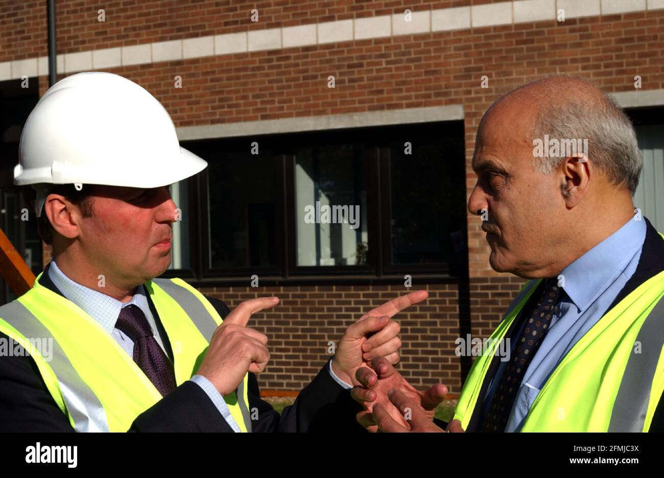 GESUNDHEITSMINISTER ALAN MILBURN TRAF HEUTE PROFESSOR SIR MAGDI YACOUB (RECHTS IM BILD) , DEN FORSCHUNGSDIREKTOR DER HAREFIELD RESEARCH FOUNDATION, ALS ER MIT DEM BAU EINER ERWEITERUNG DES HERZ-WISSENSCHAFTSZENTRUMS AUF DEM GELÄNDE DES HAREFIELD-KRANKENHAUSES BEGANN, DURCH ANZIEHEN EINES HARDHUT UND SCHNEIDEN DES ERSTEN RASENS IN EINEM MECHANISCHEN BAGGER. 31. OKTOBER 2001 PIC:JOHN VOOS Stockfoto