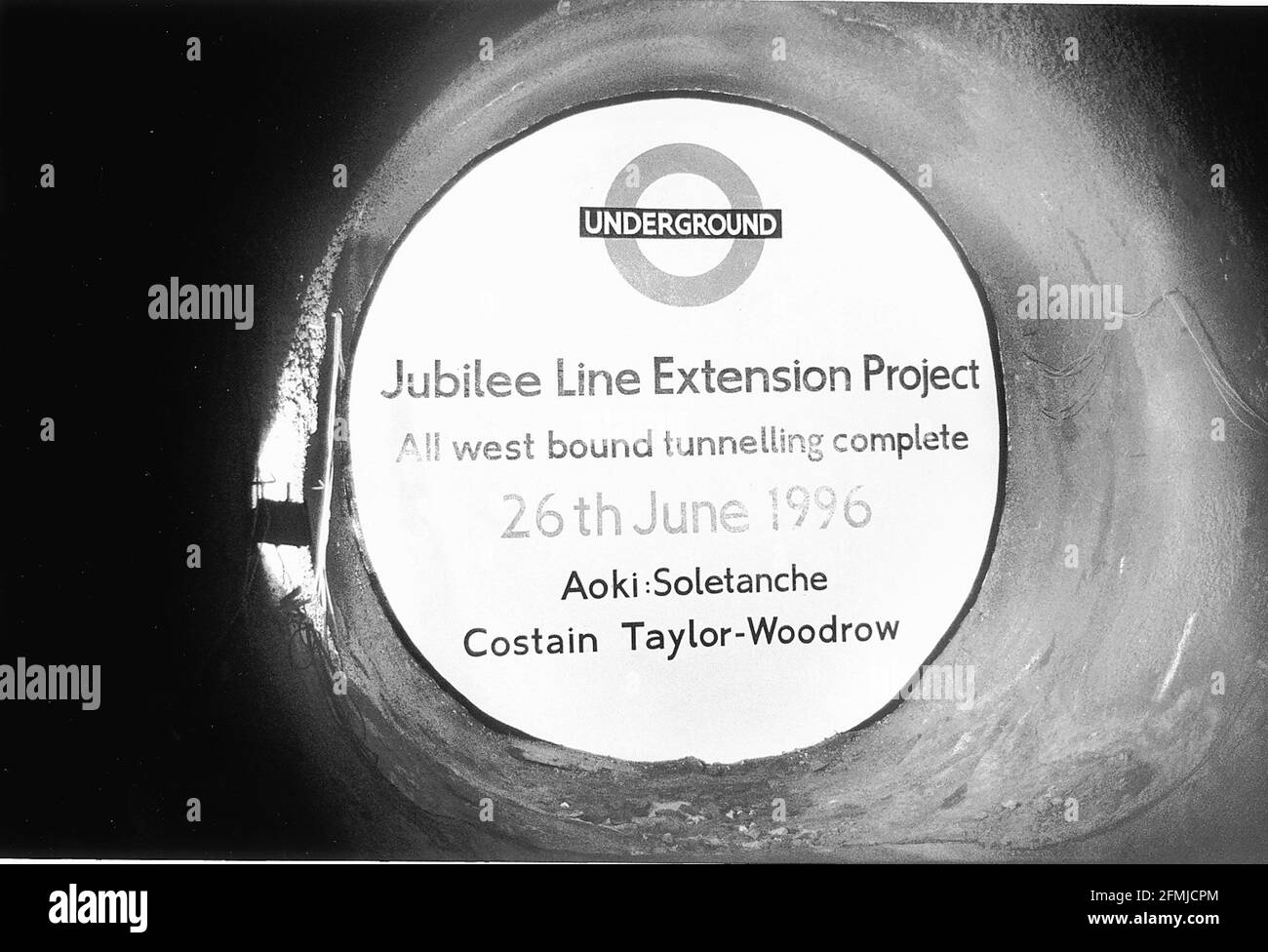 35 METER UNTER DER ERDE. BEI DER DURCHBRUCHZEREMONIE FÜR DIE JUBILEE-STRECKENVERLÄNGERUNG STEHT EINE TUNNELBOHRMASCHINE KURZ VOR DEM ABSTURZ DURCH EINE NEU GEBAUTE BREEZEBLOCK-WAND Stockfoto
