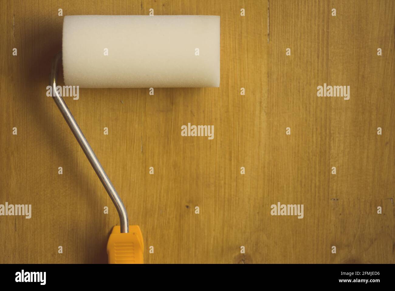Nahaufnahme einer Farbwalze auf einem Holzhintergrund. Stockfoto