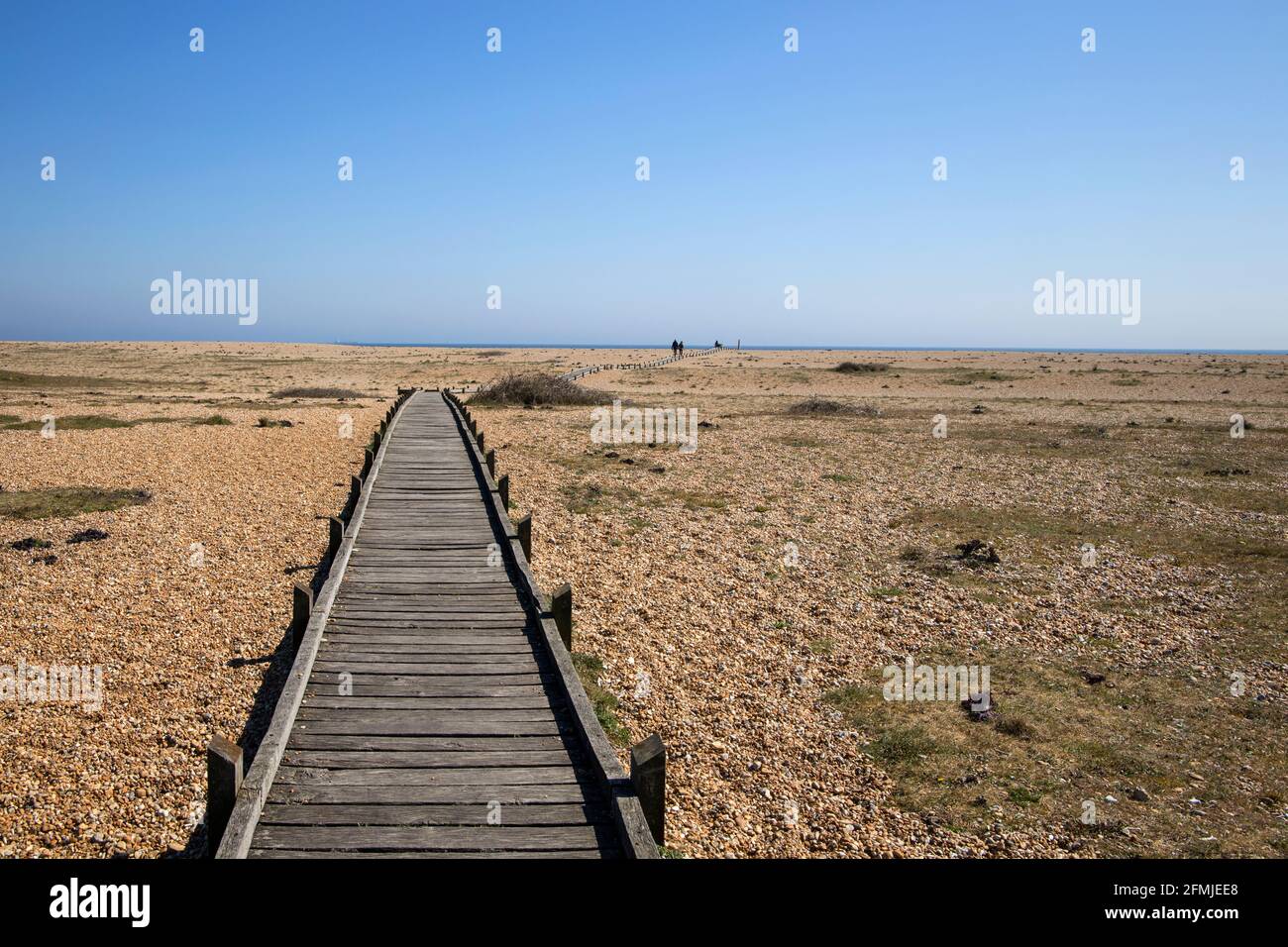 Holzbrett zu Fuß über den riesigen Kiesstrand in Dungeness kent Stockfoto