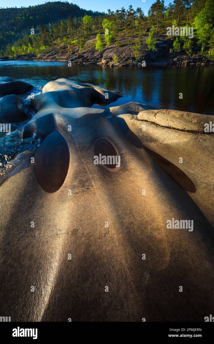 Am frühen Morgen Sonnenlicht auf der schönen Landschaft mit blank polierten Felsen und bewaldeten Hügeln bei Reinsfoss in Nissedal, Telemark, Norwegen, Skandinavien. Stockfoto