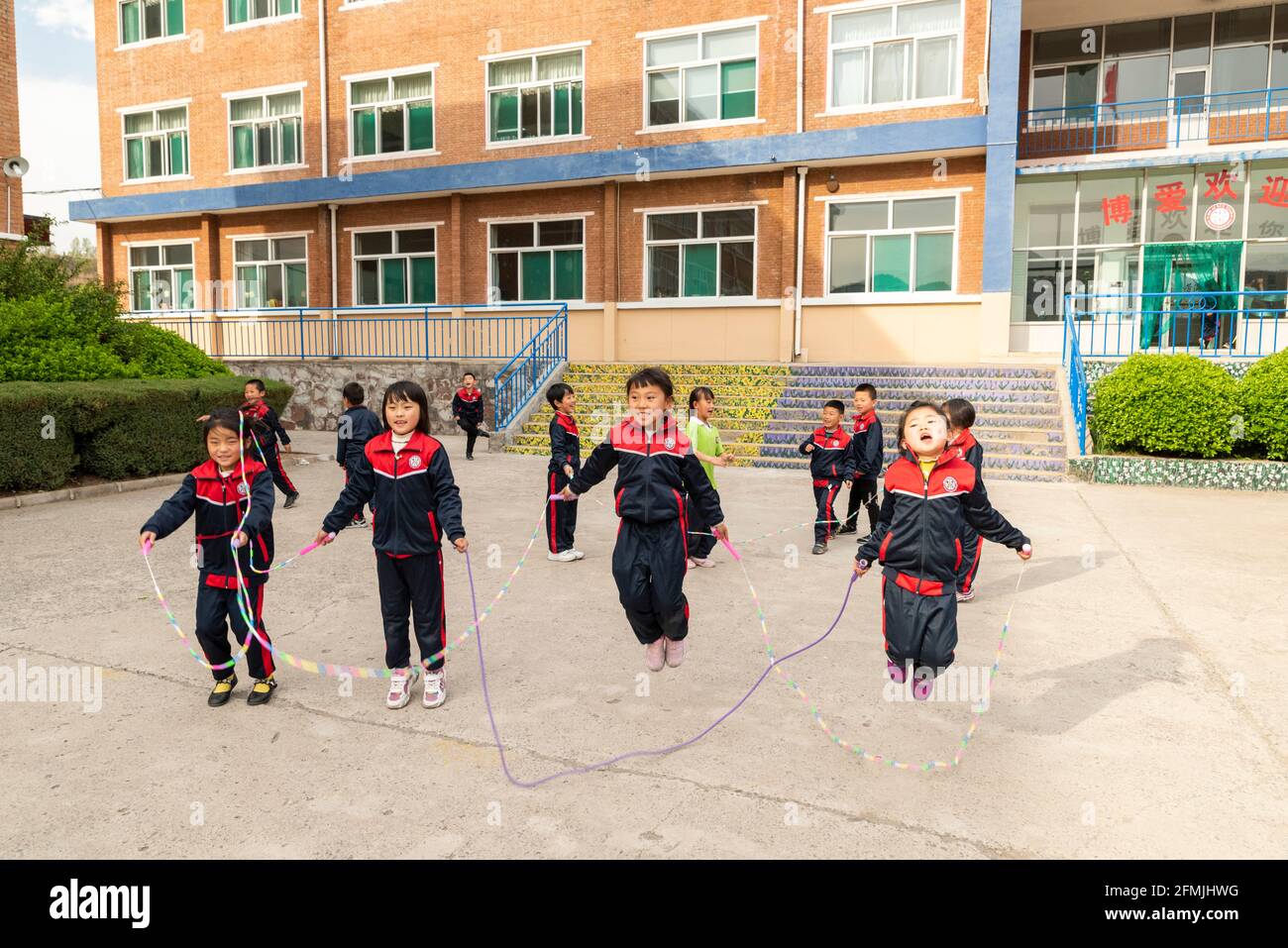 Schüler springen während ihrer Pause an der BOAI-Schule in Shanxi, China, Seil Stockfoto
