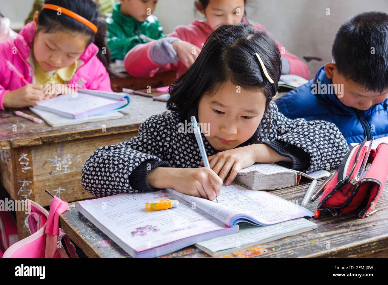 Schüler, die ihren Chinesischunterricht in einer ländlichen Schule in Congqing, China, machen. Stockfoto