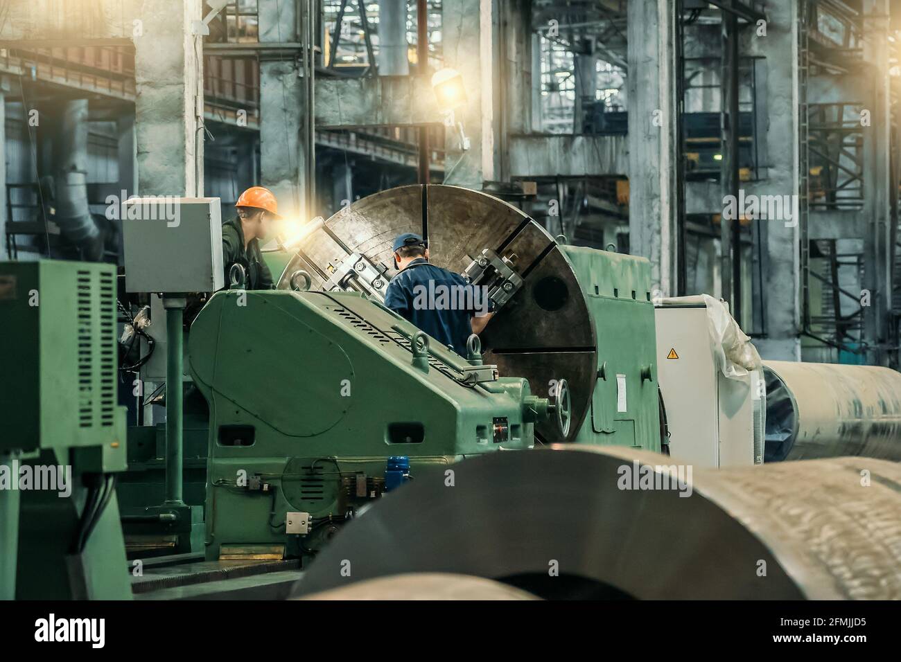 Werkarbeiter Wartung Drehmaschine automatische Bearbeitung in der Werkstatt. Metallbearbeitungsmaschine Schwerindustrie. Stockfoto