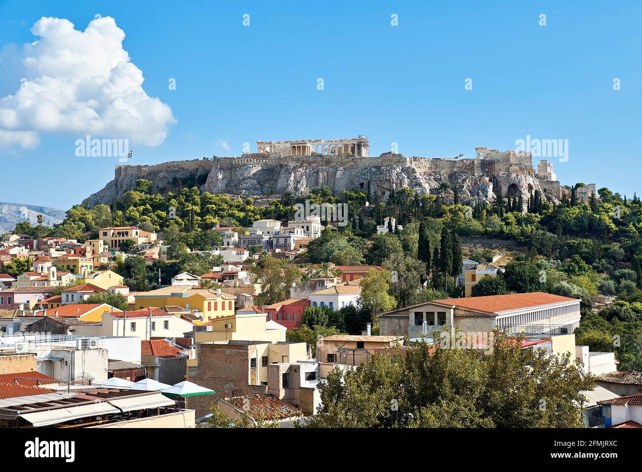 Akropolis-Hügel mit alten Tempeln und Dächern von Häusern in Athen, Griechenland, mit blauem Himmel. Stockfoto