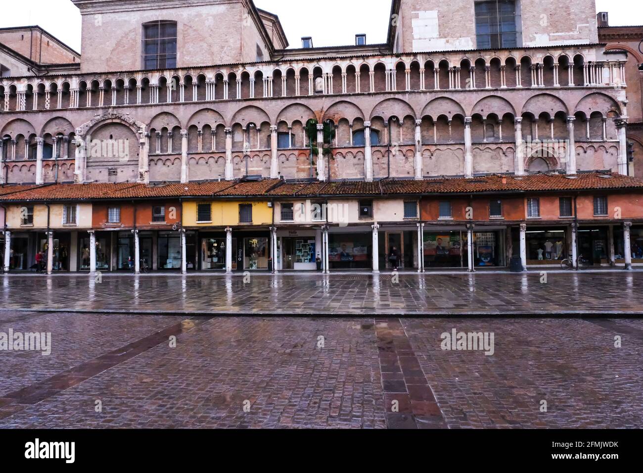 Die Seitenwand der Kathedrale von Ferrara und Geschäfte In Italien Stockfoto