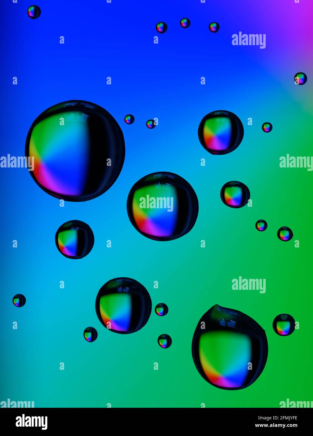 Schöne farbige Beugungseffekte von Wassertröpfchen auf Glas gegen Ein mehrfarbiger Hintergrund Stockfoto