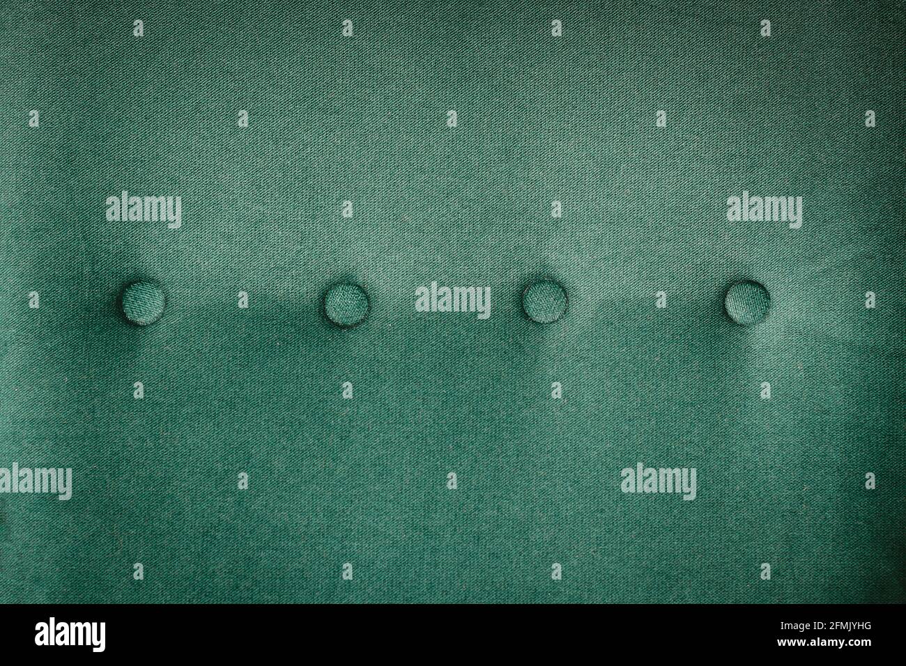 Rückseite des Sessels gesteppt mit Knöpfen grünen Stoff Hintergrund Stockfoto