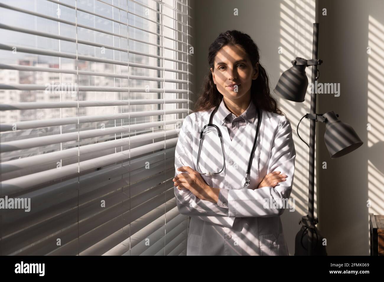 Porträt einer jungen hispanischen Ärztein im Büro Stockfoto