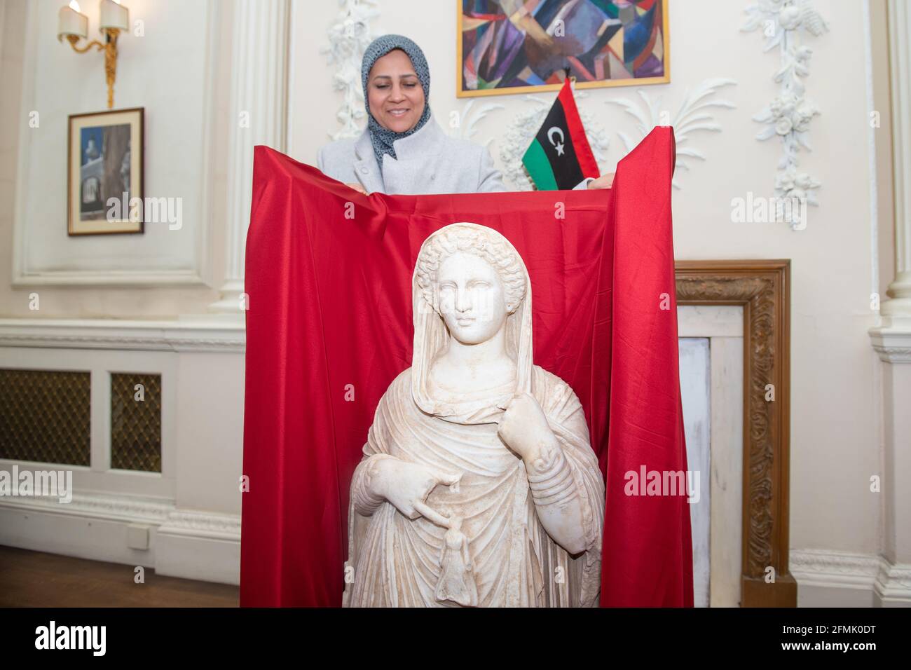 Erster Sekretär der Lybischen Botschaft, Enas Kaal, mit der Grabstatue aus dem zweiten Jahrhundert, die Demeter oder Persephone in der libyschen Botschaft im Zentrum von London darstellt. Die Statue wird mit Hilfe der Regierung, der libyschen Botschaft und des British Museum zurückgegeben, nachdem sie vom HMRC beschlagnahmt wurde, als sie von einem Händler illegal aus Libyen nach Großbritannien gebracht wurde. Ausgabedatum: Montag, 10. Mai 2021. Stockfoto