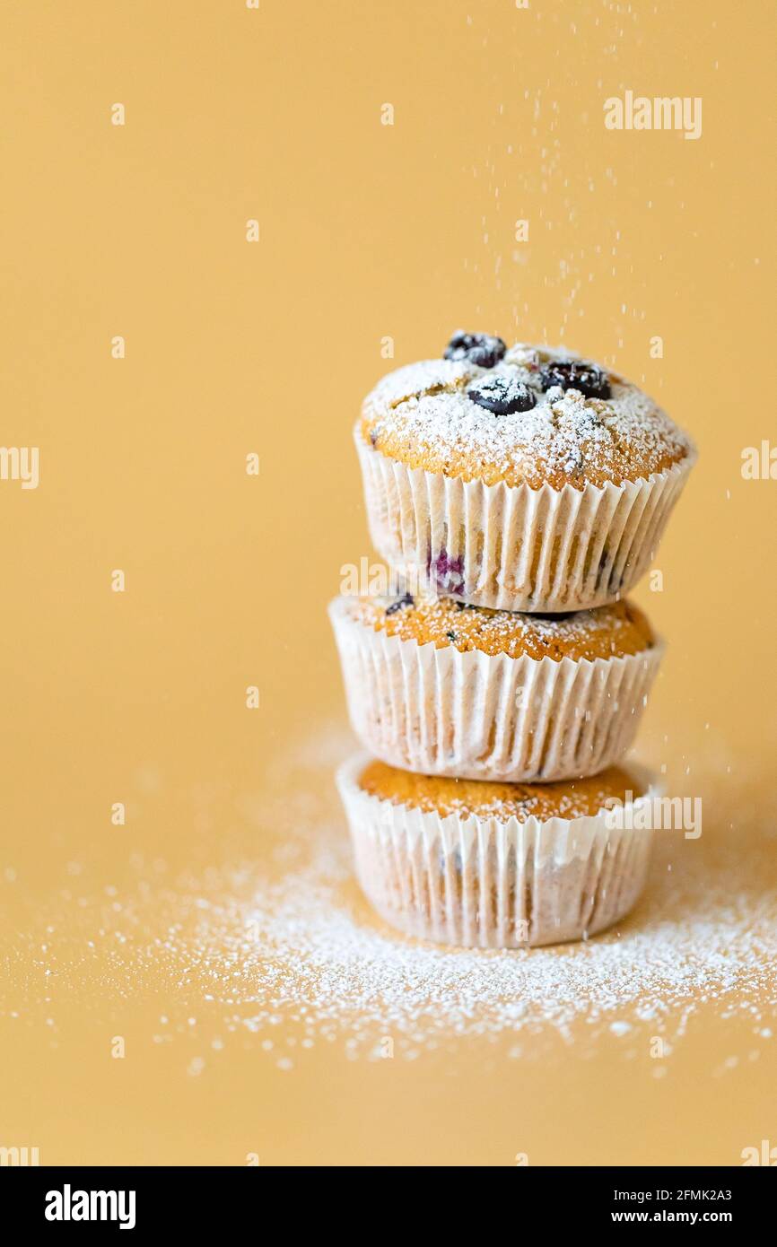 Drei Muffins, geheftet mit blauem und orangefarbenem Hintergrund Stockfoto