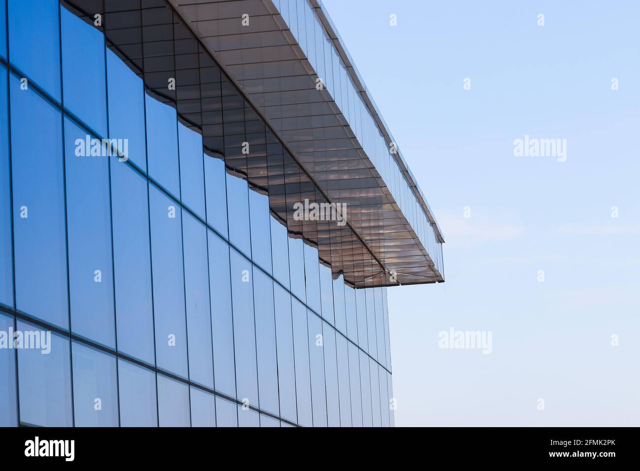 Fragment des neuen, modernen Gebäudes mit Fenstern und blauen Buntglasfenstern. Stockfoto