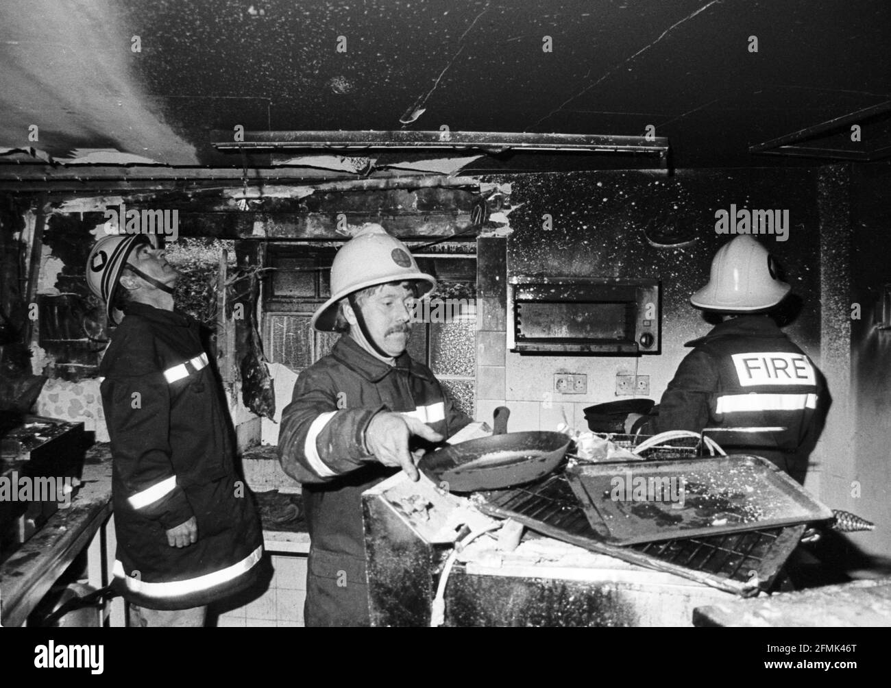 Eine Wiltshire-Feuerwehr greift auf den Schaden eines Küchenbrands in Salisbury Ende der 1980er Jahre zu. Stockfoto