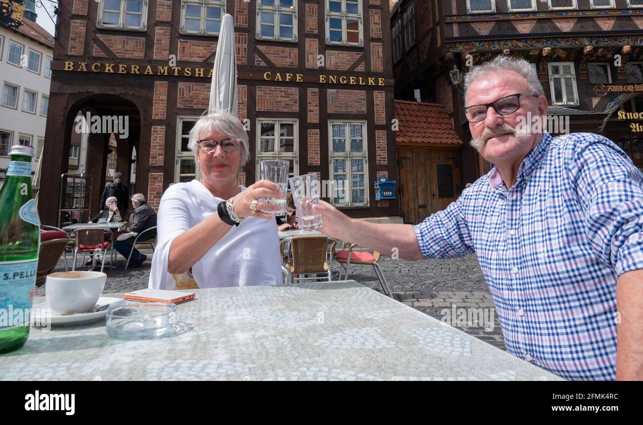 Hildesheim, Deutschland. Mai 2021. Petra und Reinhard Walther, beide voll gegen das Corona-Virus geimpft, sitzen im Freiluftrestaurant des Bäckeramtshauses auf dem Marktplatz. Mit entsprechenden Inzidenzen in den Bezirken treten Lockerungen der Corona-Verordnung in Kraft. So darf sich unter anderem die Outdoor-Gastronomie unter Bedingungen öffnen. Quelle: Julian Stratenschulte/dpa/Alamy Live News Stockfoto