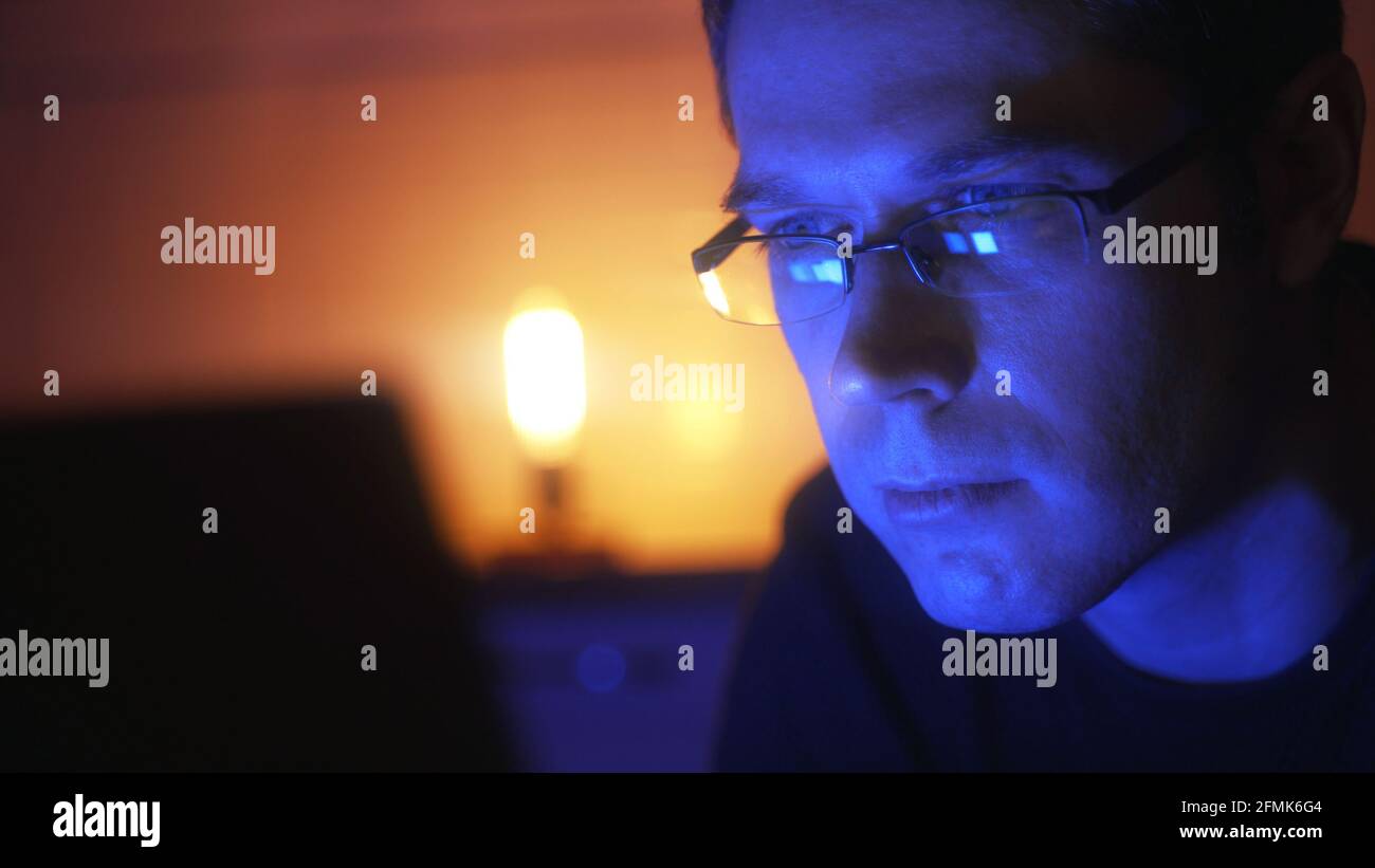 Mann in Brille mit Laptop-pc am Abend zu Hause. Stockfoto