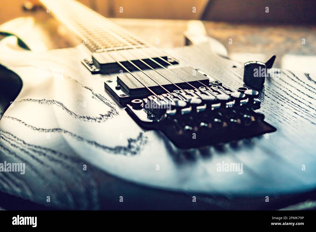 Nahaufnahme einer hölzernen E-Gitarre mit sechs Saiten, selektiver Fokus auf Saiten Stockfoto