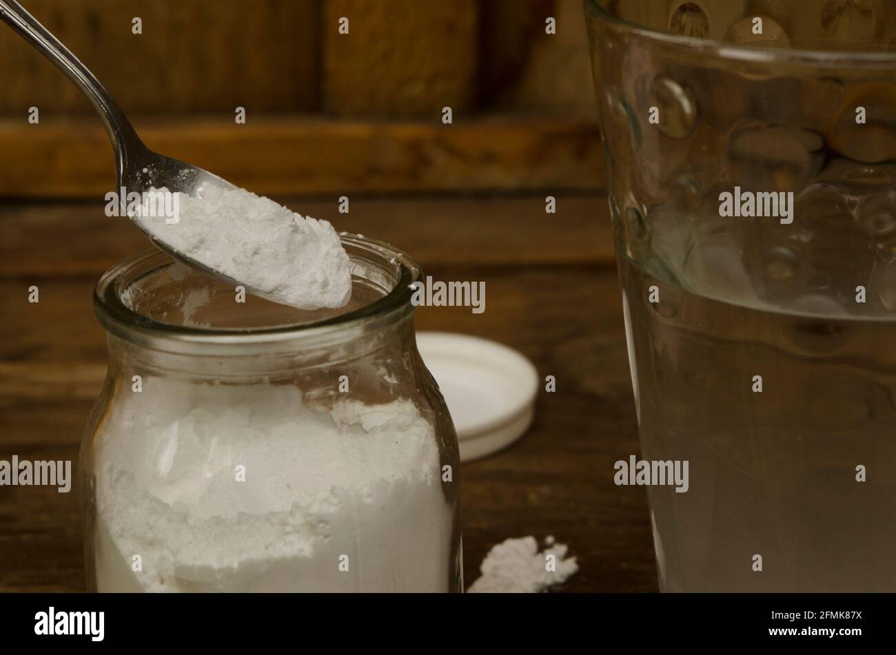 Natriumbicarbonat und Glas Wasser, Lösung mit mehreren Verwendungen. Weißes Pulver wie Talkum Stockfoto