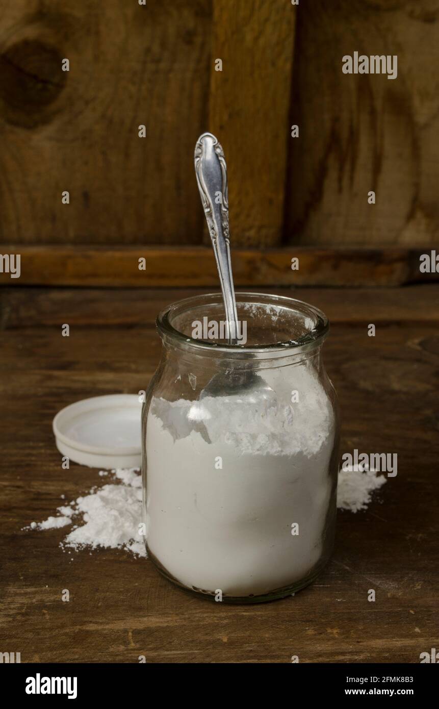 Backpulver in einem Glas mit Holzboden oder Backpulver in einem Glas, Zutat für Kuchen und viele weitere Anwendungen Stockfoto