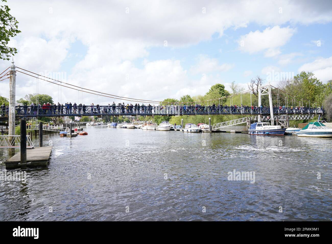 Auf der Fußgängerbrücke bei Teddington Lock versammeln sich Menschen, um einen drei bis vier Meter langen Minke-Wal zu erspähen, der am Sonntag freigelassen wurde, nachdem er auf Richmond lockÕs Bootswalzen stecken geblieben war, aber in der Themse geblieben ist. Bilddatum: Montag, 10. Mai 2021. Stockfoto