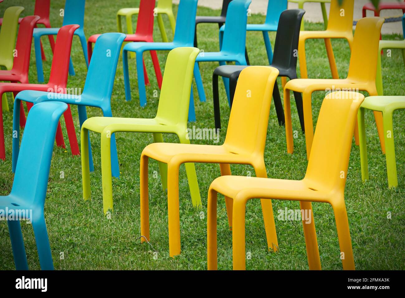 Reihe von bunten leeren Stühlen für eine Veranstaltung im Freien Stockfoto