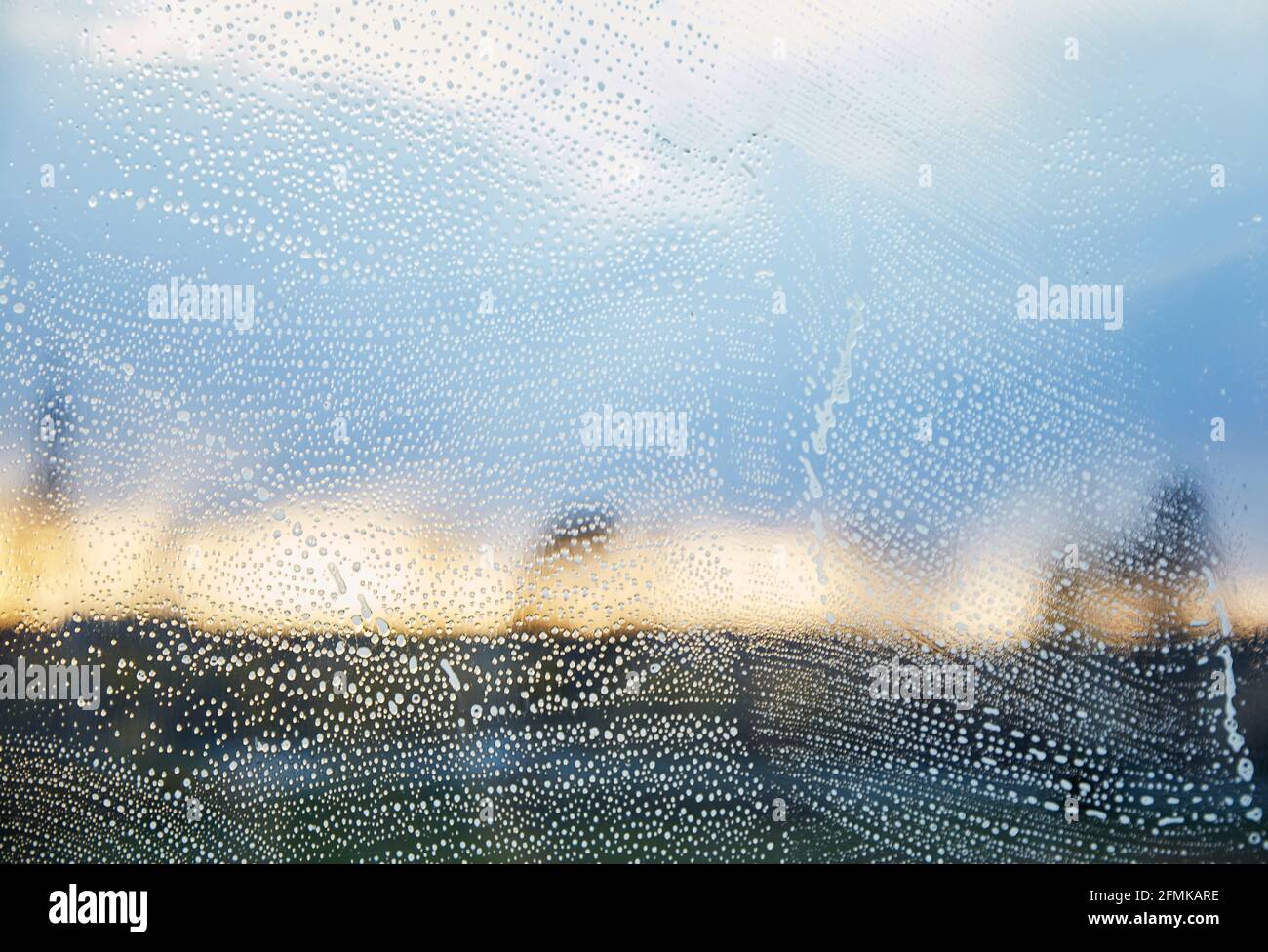 SOAP-Fenster. Frühjahrsputz-Konzept. Desinfizieren und reinigen durch die Pandemie, covid 19. Blaugrün und orange. Die Hand wascht das Fenster zu Hause bei Abendlicht. Reflexionseffekt. Speicherplatz kopieren Stockfoto