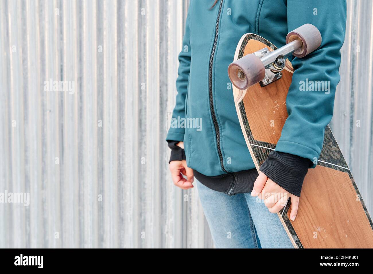 Gesichtsloses Mädchen, das ihr Skateboard hält. Platz für Text kopieren. Konzept des nachhaltigen Transports und einer gesunden Lebensweise. Stockfoto